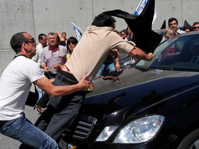 Manifestantes sobem para cima do carro do ministro da Economia - TVI