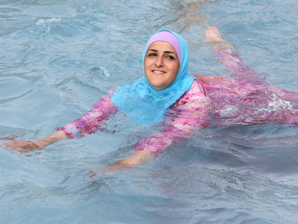 Mulher toma banho na Alemanha vestida com um burkini