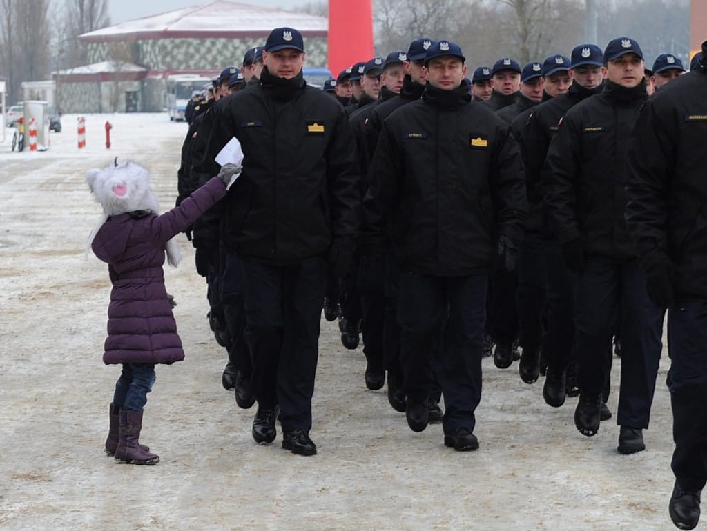 Menina entrega bilhete de despedida ao pai que participa em missão da NATO (EPA/MARCIN BIELECKI)