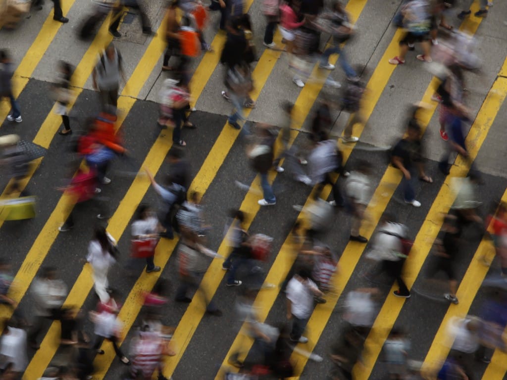 Peões atravessa rua em Hong Kong, na China (Reuters)