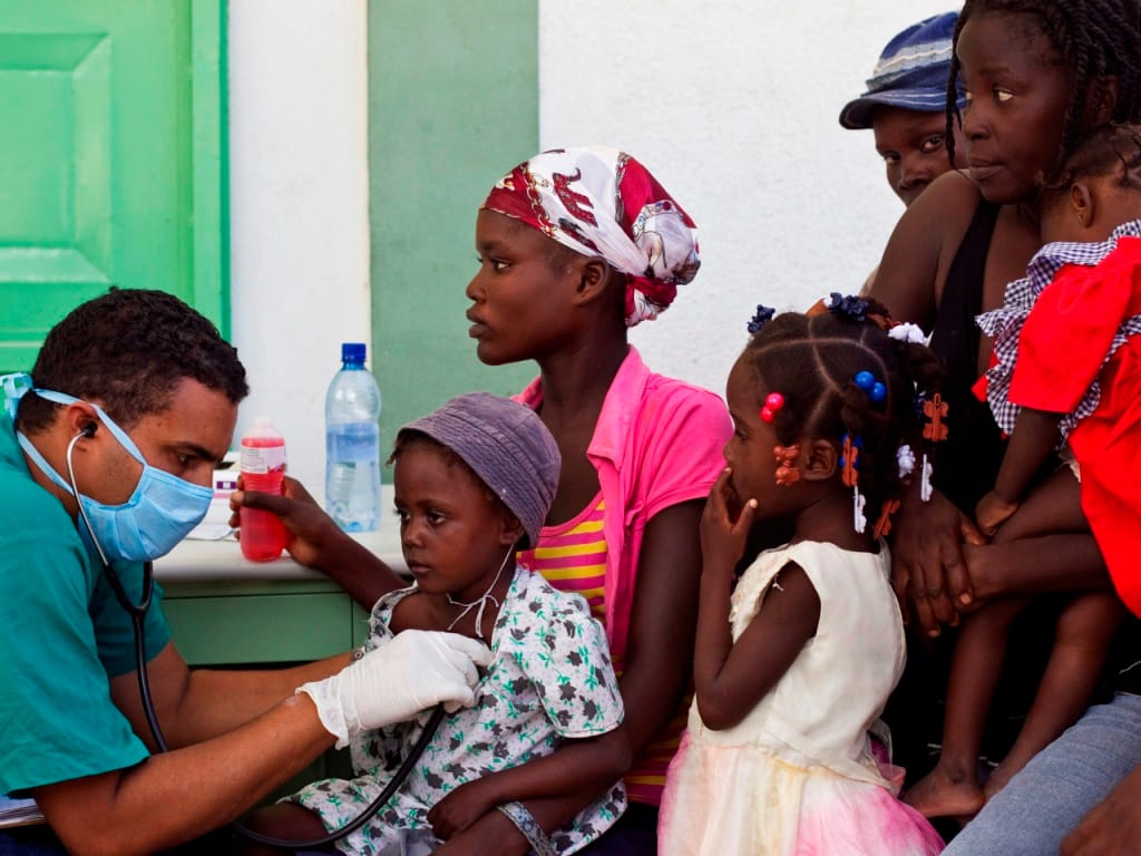 Médico cubano presta auxílio a crianças infetadas (foto: Reuters)