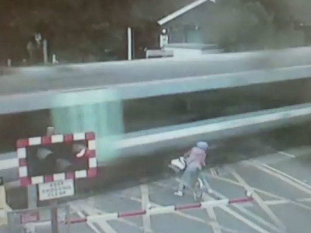 Ciclista quase é colhida por comboio (Youtube)