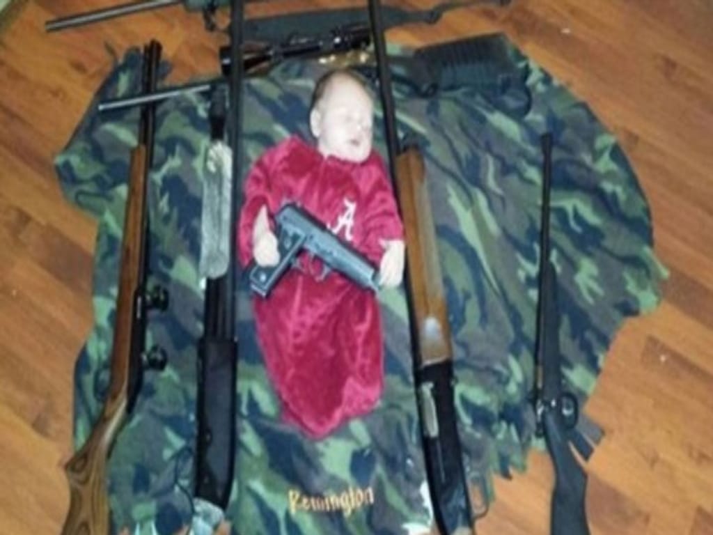 Foto mostra bebé a dormir com armas (Foto:Reprodução/Twitter)