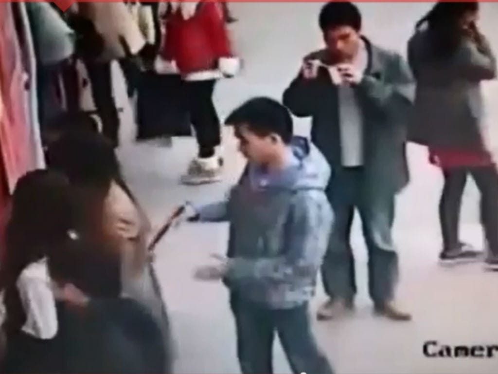 Carteirista com «pauzinhos» rouba telemóvel na China (Reprodução Youtube)
