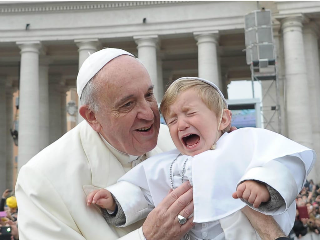 Criança chora ao ser beijada pelo Papa Francisco [EPA]