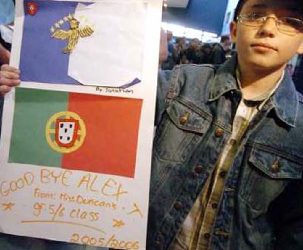 Alex de 9 anos, nasceu no Canadá, segura um cartaz de despedida da professora e colegas da escola. À chegada aos Açores