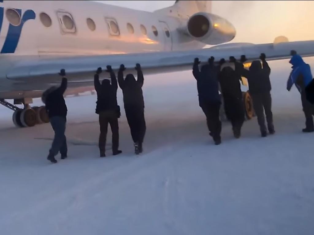 Russos empurram avião preso no gelo