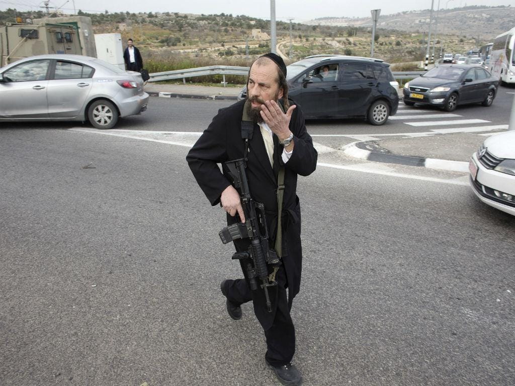 Israelita armado junto ao posto de controlo onde ocorreu um suposto ataque com ácido (REUTERS)