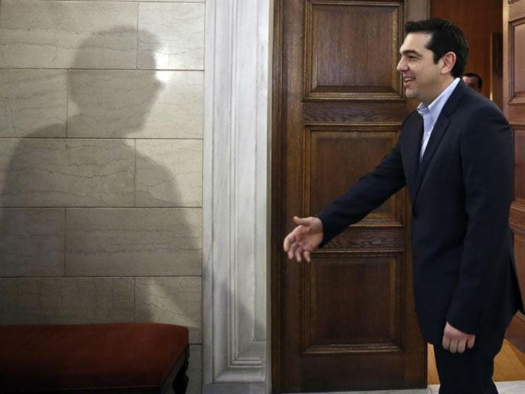 A sombra do presidente do Eurogrupo «cumprimenta» Alexis Tsipras em Atenas. REUTERS/Petros Giannakouris