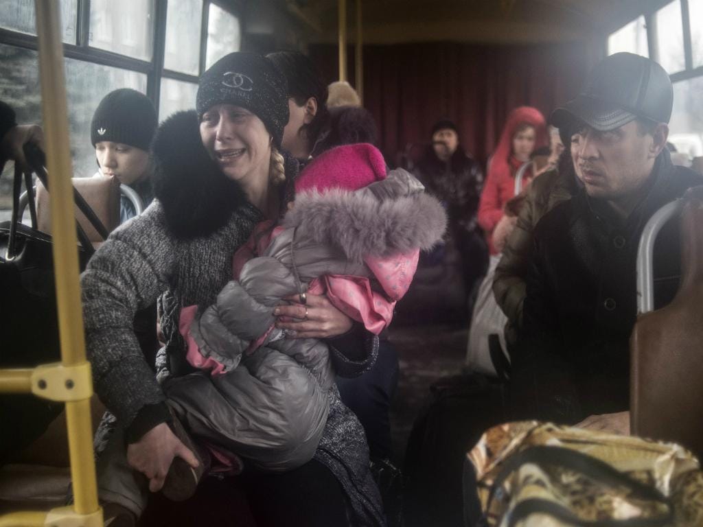 Pessoas sentadas num autocarro para fugir dos bombardeamentos (Reuters)