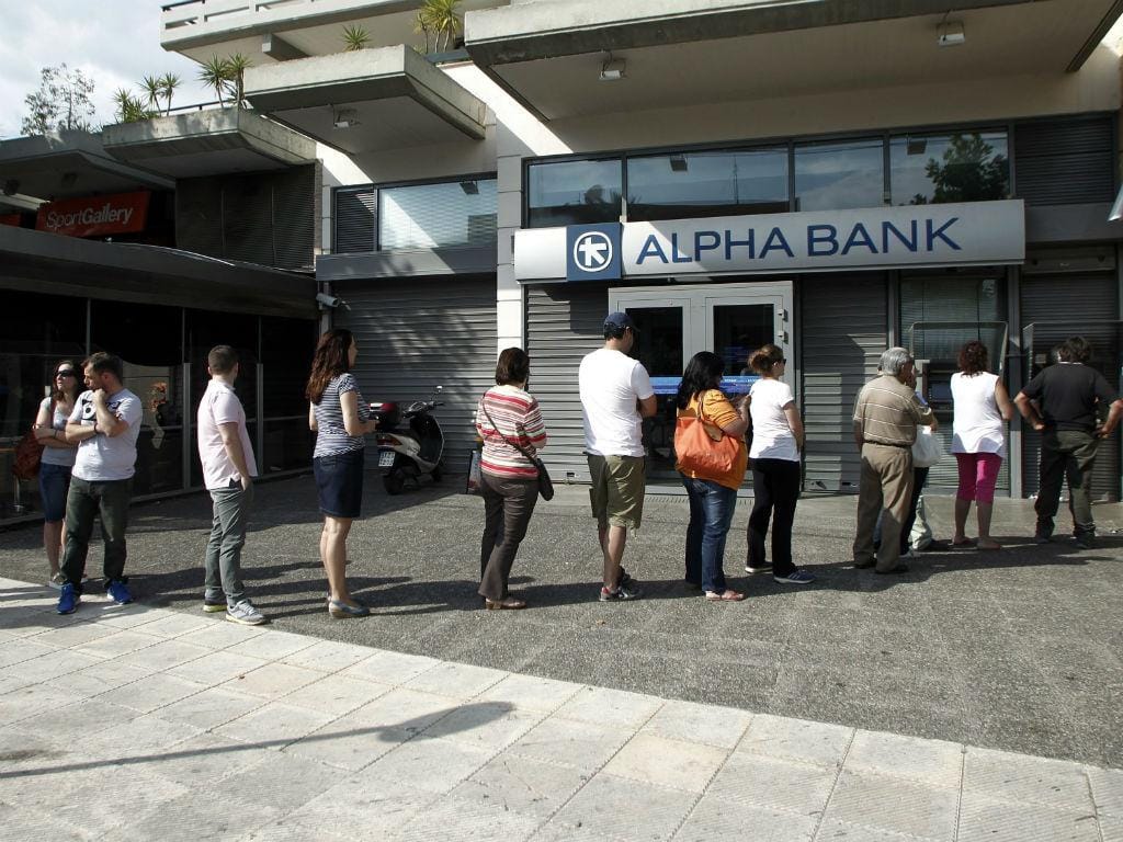 Gregos fazem fila para levantar dinheiro numa caixa multibanco. EPA/ALEXANDROS VLACHOS