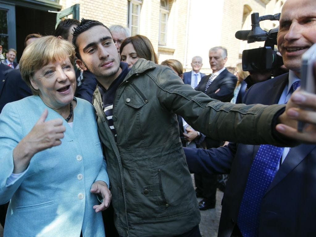 Refugiados tiram "selfies" com Angela Merkel [Fonte: Reuters]