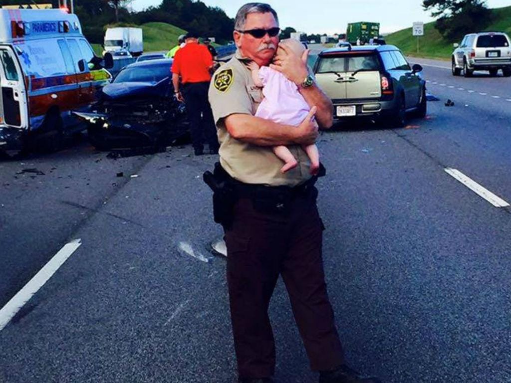Polícia conforta bebé após acidente (Reprodução Facebook)