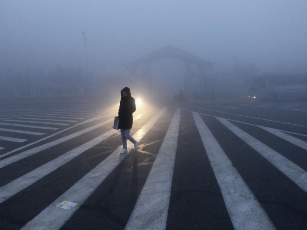 Uma mulher anda ao longo de uma rua durante um dia de poluição em Changchun, na província de Jilin (REUTERS / China Daily)