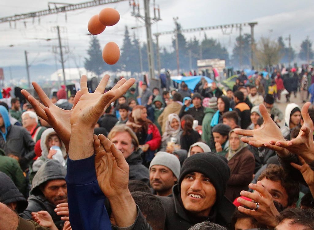 Refugiados recebem comida na fronteira da Grécia com a Macedónia
