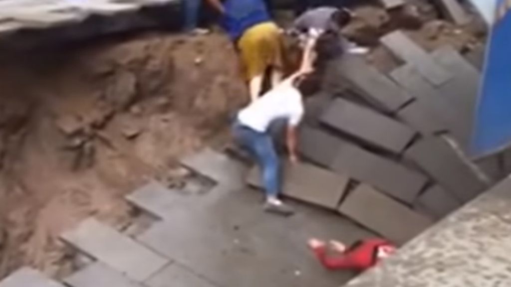 Buraco "engole" duas pessoas na China [Foto: Reprdoução / Youtube]