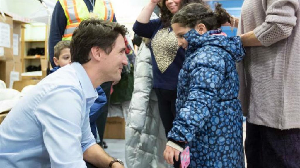 Justin Trudeau recebe criança síria, no aeroporto de Toronto