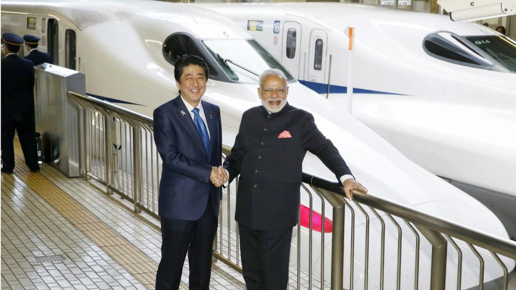 Primeiros-ministros indiano, Narendra Modi, e japonês, Shinzo Abe, junto ao comboio-rápido de Shinkansen