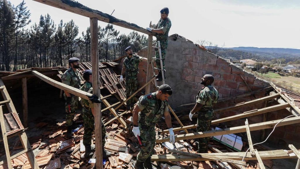 Fuzileiros da Marinha portuguesa colocam um toldo para substituir o telhado de uma habitação destruída, durante o incêndio, em Pedrógão Grande