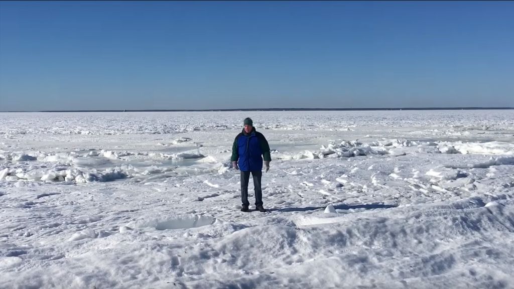 Homem caminha sobre águas do mar congeladas 