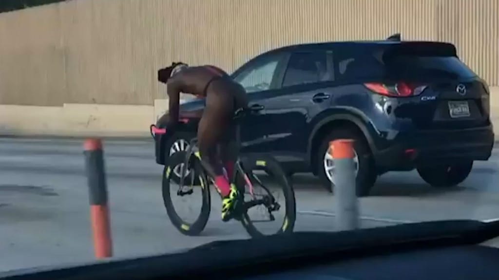 Ciclista nu na autoestrada (reprodução vídeo do «Miami Herald»)