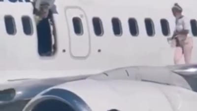 “Preciso de apanhar ar”. Vídeo mostra passageira a andar sobre asa de avião após abrir porta de emergência - TVI