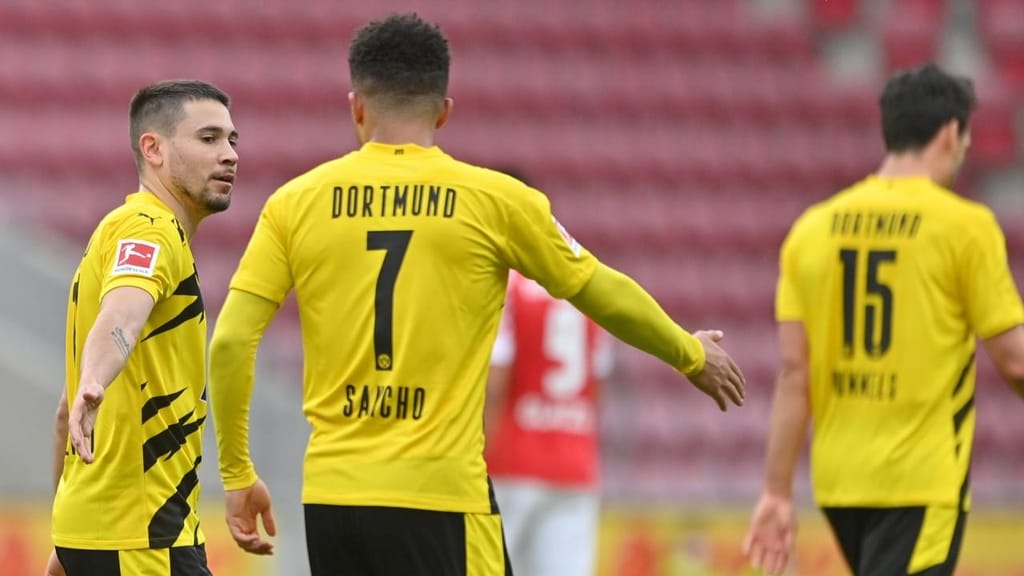 Raphäel Guerreiro festeja com Jadon Sancho um golo no Mainz-Borussia Dortmund (Sascha Steinbach/EPA)