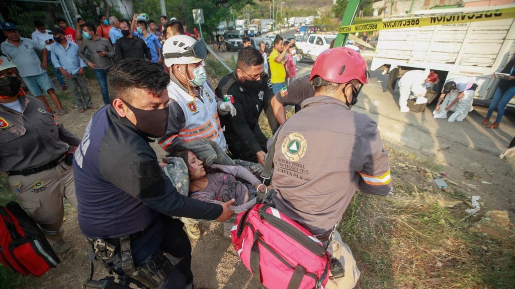 Mulher é ajudada pela Proteção Civil de Chiapas após acidente com camião que transportava migrantes (AP)