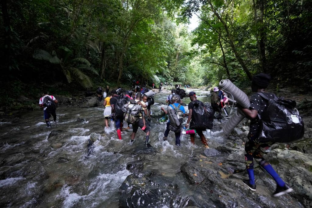 15 de setembro, migrantes cruzam o rio Acandi, perto de Acandi, Colômbia, a caminho da montanha de Darien para tentar chegar aos EUA (Fernando Vergara, AP)