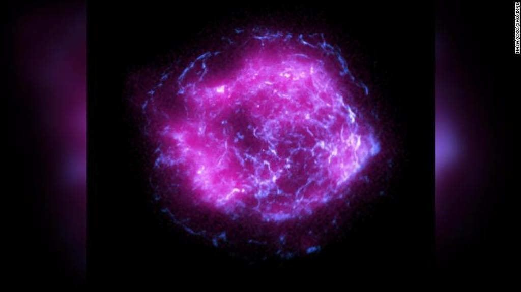 Esta imagem mostra vestígios remanescentes da supernova Cassiopeia A, e combina os primeiros dados de raios-X recolhidos pelo Imaging X-ray Polarimetry Explorer da NASA, a roxo, com dados de raios-X de alta energia do Observatório de Raios-X Chandra da NASA, a azul.