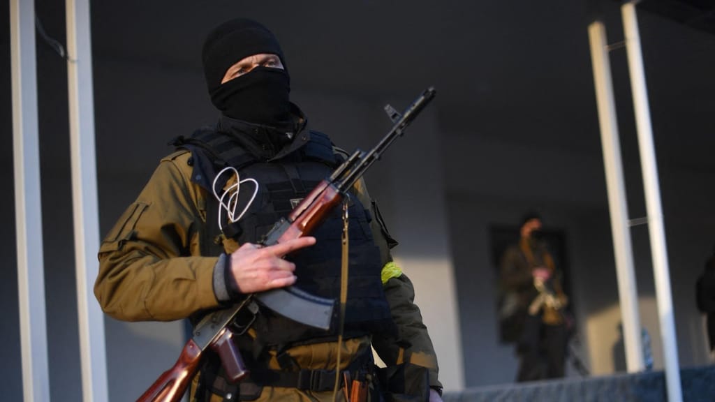 Um civil armado é visto nas ruas de Kiev. Muitos voluntariaram-se para proteger a cidade Foto: Daniel Leal/AFP via Getty Images