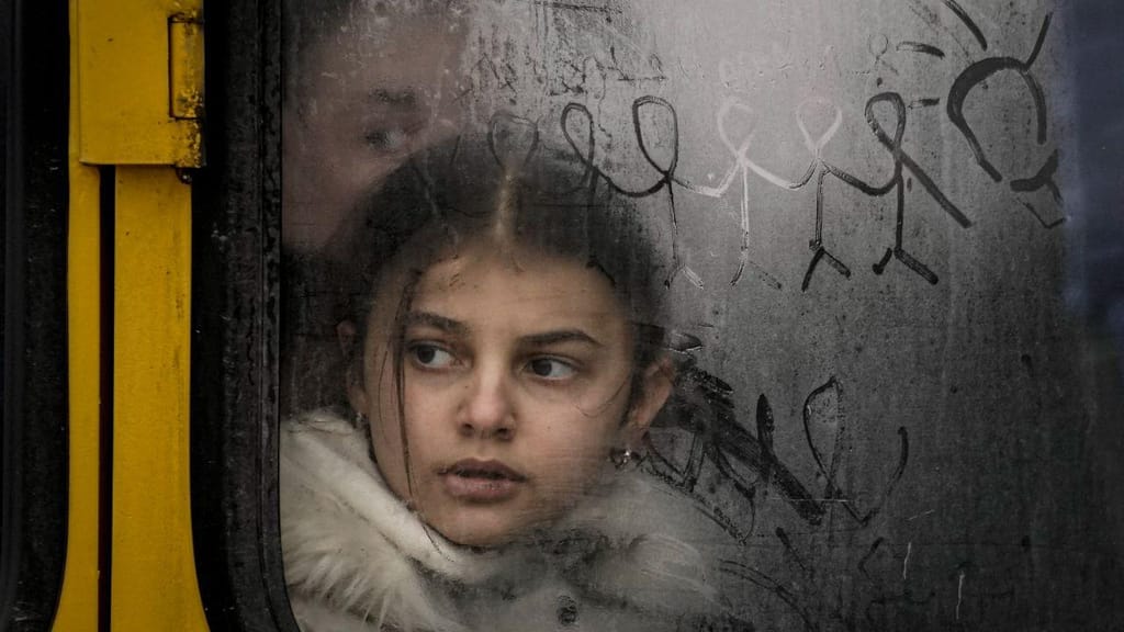 Criança olha pela janela de um autocarro em Irpin, nos arredores de Kiev (AP)