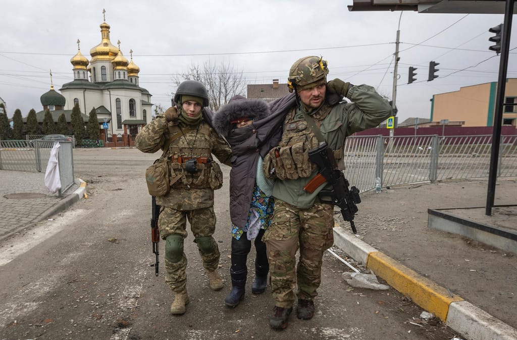 Soldados ucranianos ajudam a retirar uma senhora da cidade de Irpin, na Ucrânia. Foto: Andriy Dubchack