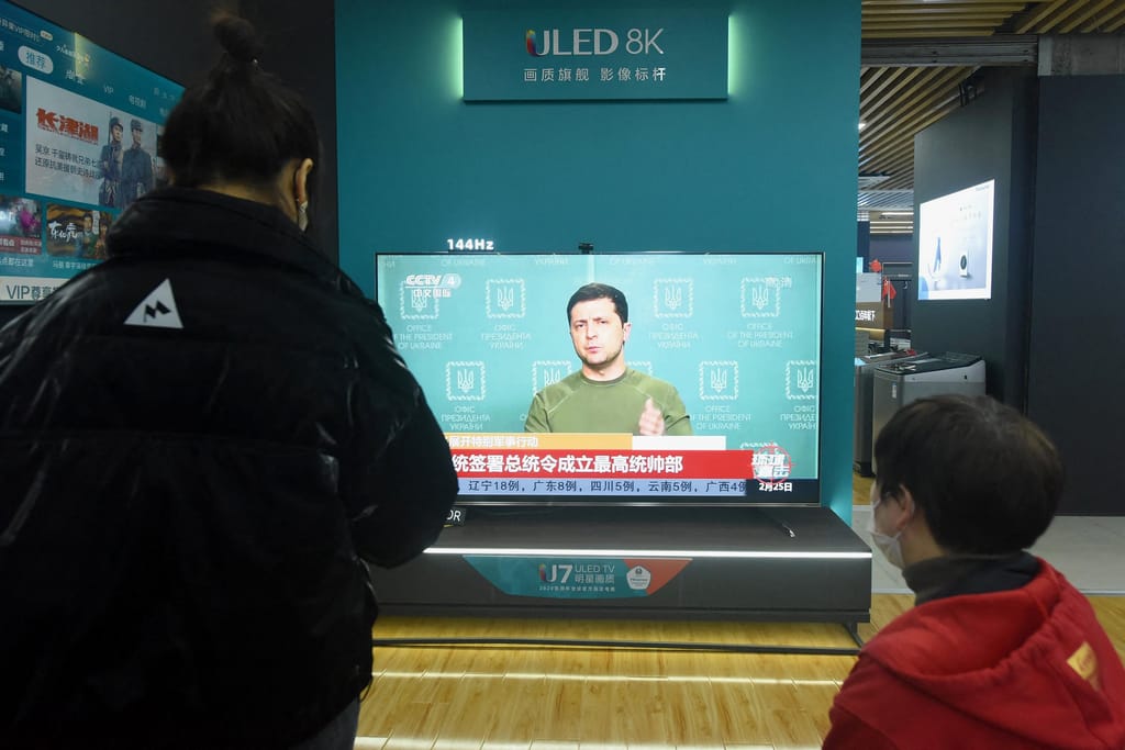 Residentes veem um ecrã de televisão com notícias sobre a Ucrânia num centro comercial em Hangzhou, na província de Zhejiang, na zona oeste da China