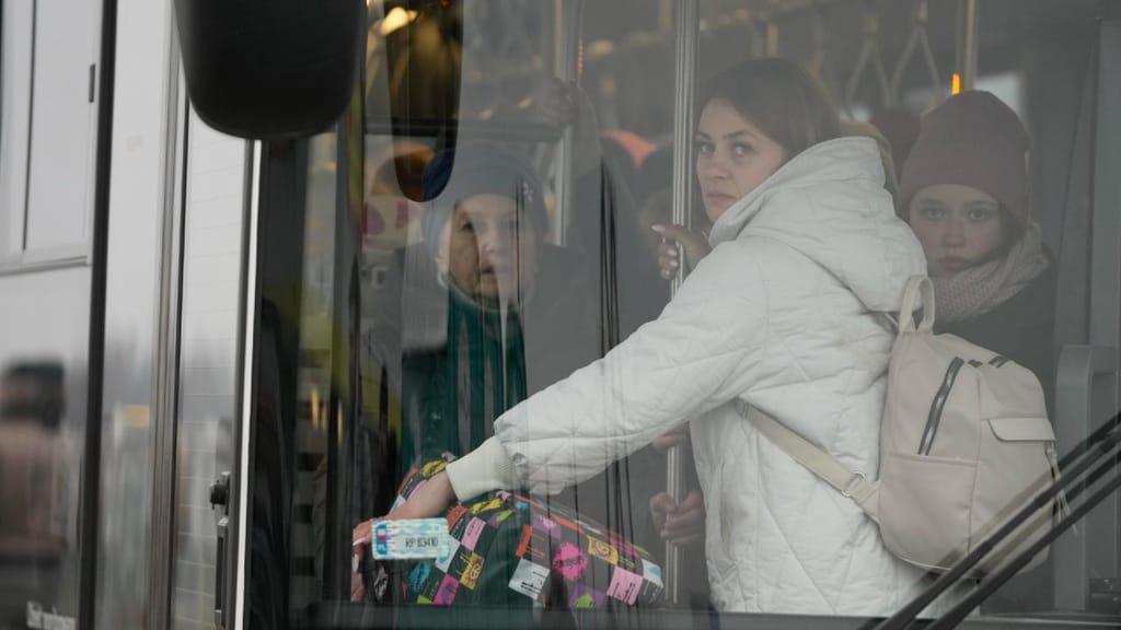 Pessoas a fugir da Ucrânia enchem um autocarro ao deixar a fronteira em Medyka, na Polónia (AP/Markus Schreiber)