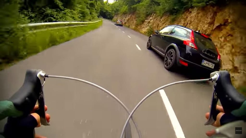 Ciclista faz descida a ultrapassar carros (captura YouTube)