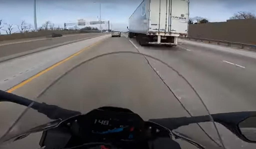 BMW S 1000 RR tenta passar entre carro e camião (captura YouTube)