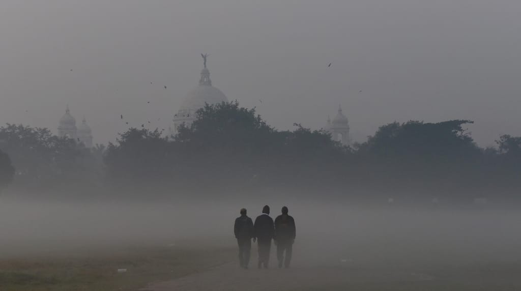 Pedestres caminhando através do denso nevoeiro em Calcutá, Índia, 15 de dezembro, 2021.
