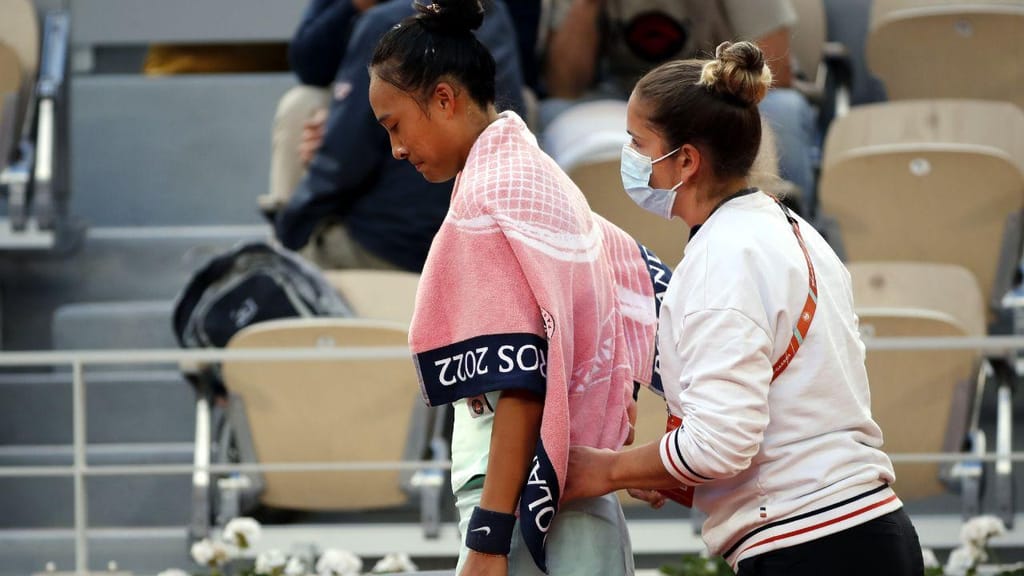 A tenista Zheng Qinwen recebe massagens durante o torneio de Roland Garros (EPA)