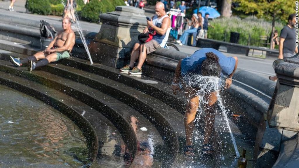 Várias pessoas tentam refrescar-se devido ao calor sufocante em agosto passado no Washington Square Park de Nova Iorque