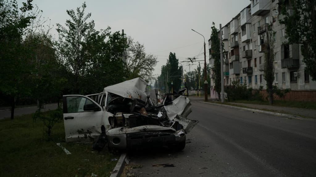 Um carro fortemente danificado é visto numa rua após um ataque russo em Severodonetsk, na região de Luhansk. (AP Photo/Leo Correa)