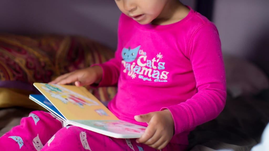 Criança a ler uma história. Inti St Clair/Tetra images RF/Getty Images