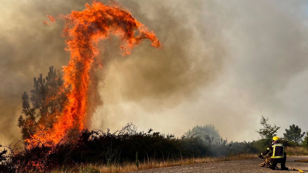 Bombeiros combatem um fogo florestal na aldeia espanhola de A Caniza, em Pontevedra (EPA/Sxenick)