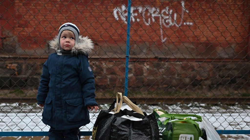 Criança espera pela mãe enquanto foge com a família de Kherson para Khmelnytskyi na Ucrânia (Artur Widak/Getty Images)