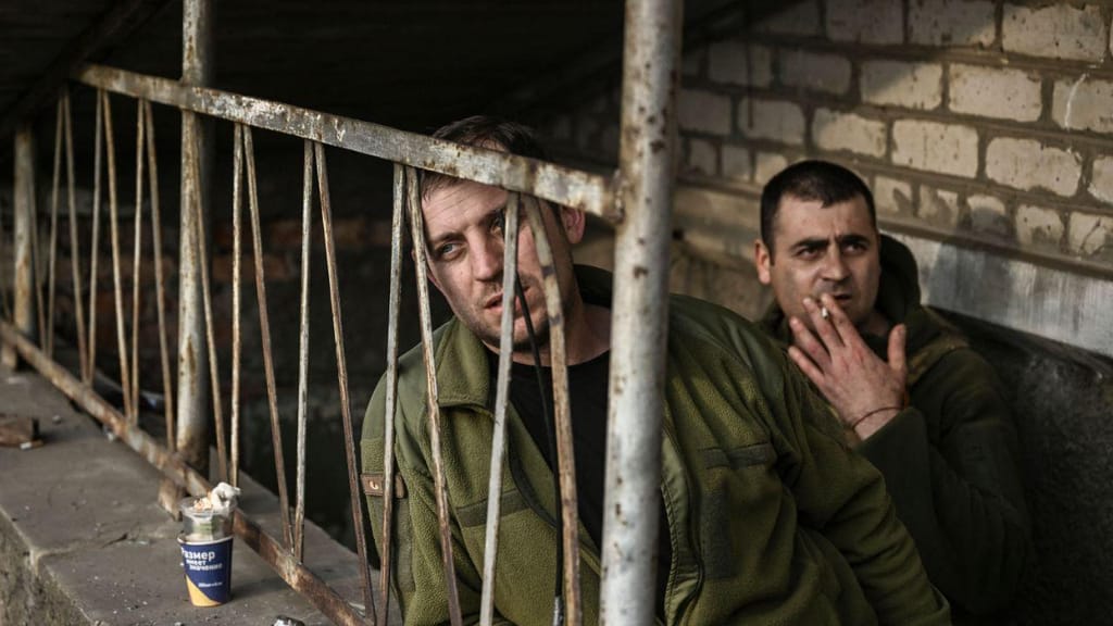 Soldados ucranianos à porta de um abrigo, no interior da cidade de Bakhmut, no final de março (Getty Images)