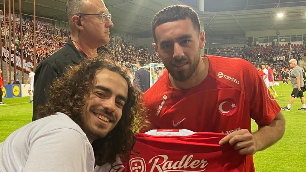 Kökcü com Lucas Robalo, adepto do Benfica, no final do Letónia-Turquia (twitter)