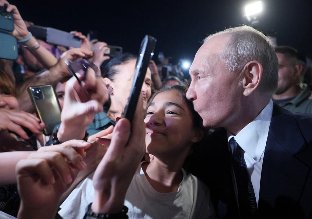 O presidente russo Vladimir Putin beija uma criança numa rua de Derbent, na região sul do Daguestão, Rússia, em 28 de junho. Gavriil Grigorov/Sputnik/Reuters