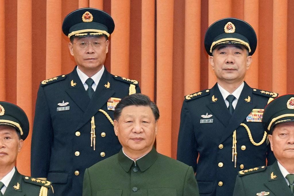 Xi Jinping com os novos líderes da Força de Mísseis Wang Houbin à esquerda e Xu Xisheng à direita, após a sua promoção ao posto de general em Pequim, a 31 de julho de 2023. Li Gang Xinhua via AP
