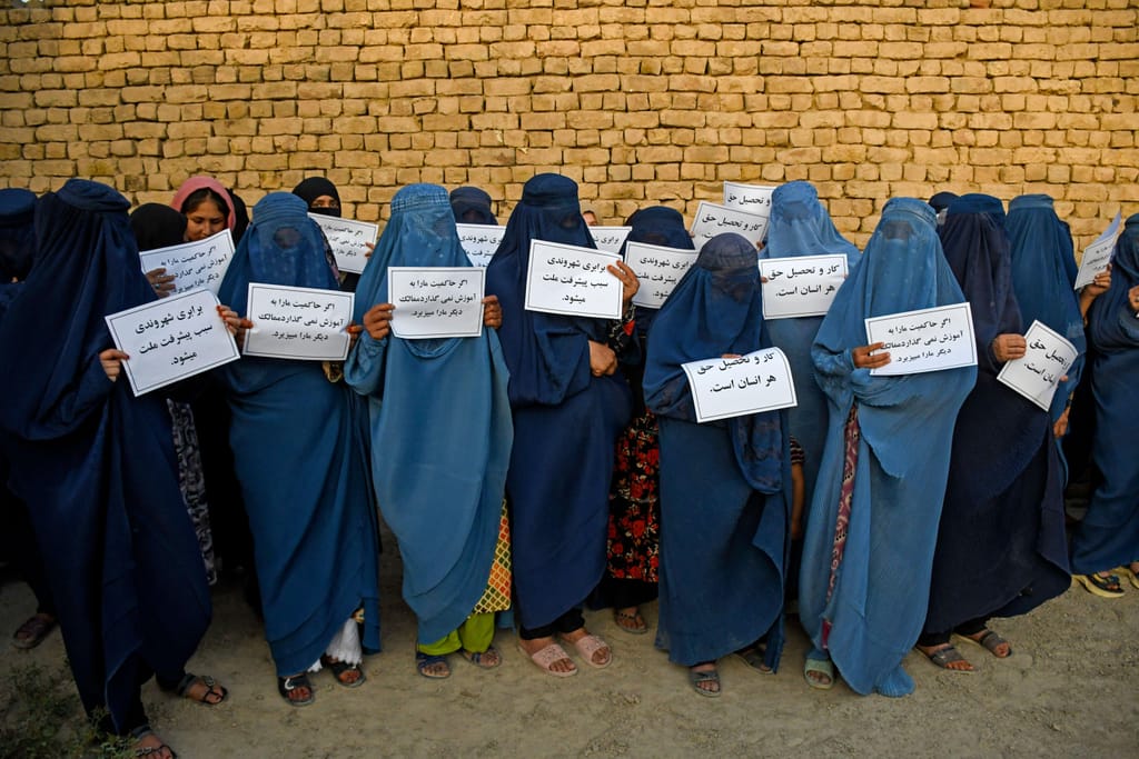 Mulheres afegãs com burca seguram cartazes em protesto pelo seu direito à educação, em Mazar-i-Sharif, a 12 de agosto de 2023. Atef Aryan _ AFP _ Getty Images