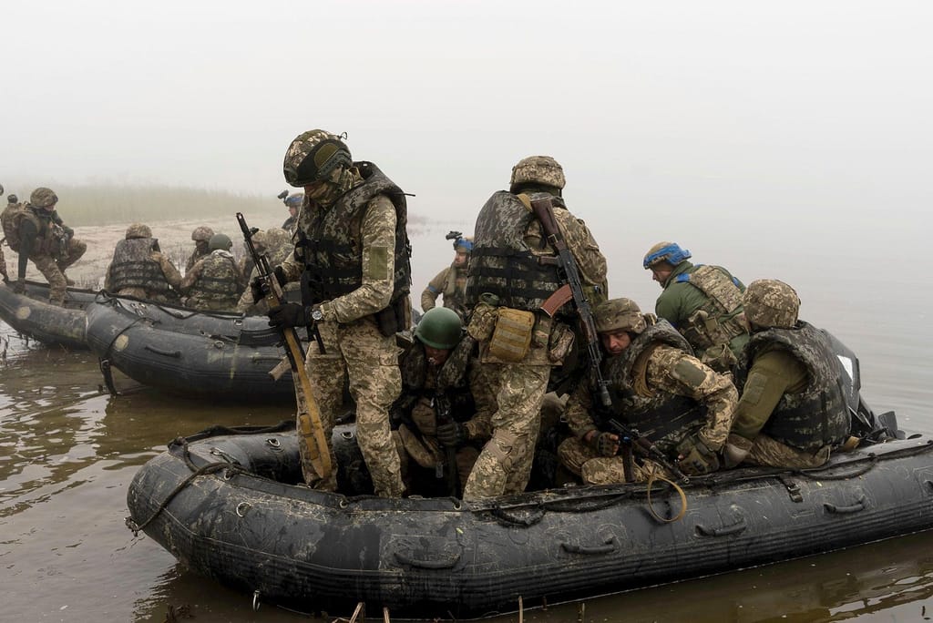 Um grupo de fuzileiros navais ucranianos navega a partir da margem do rio Dnipro, na linha da frente, perto de Kherson, na Ucrânia, a 14 de outubro de 2023. Alex Babenko/AP